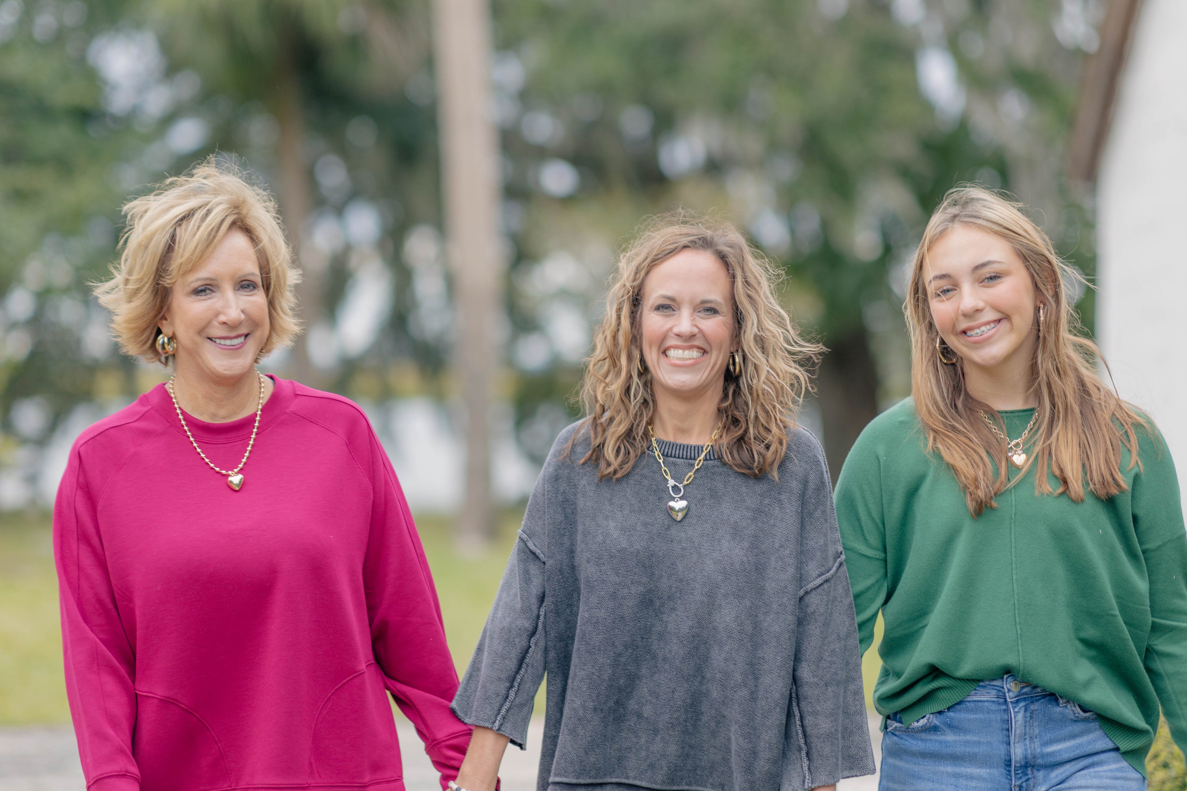 Three Stylish Women Smiling and Holding Hands
